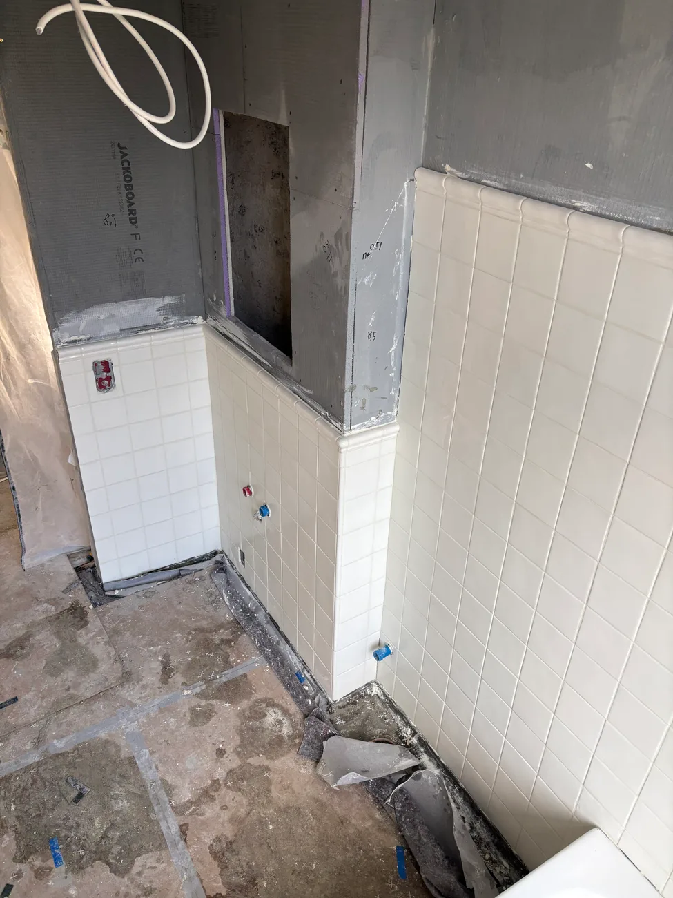 Badeværelse under renovering med nyopsatte vægfliser